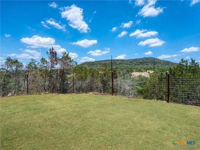 view of yard with a mountain view and fence