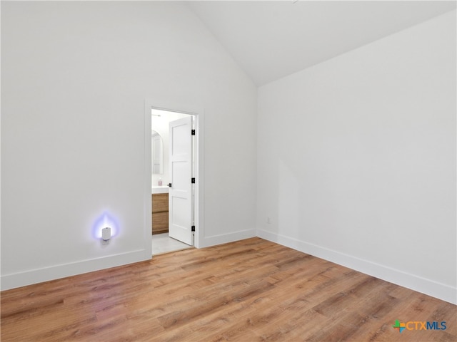 unfurnished room featuring high vaulted ceiling, baseboards, and light wood-style flooring
