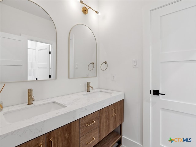 bathroom featuring a sink and double vanity