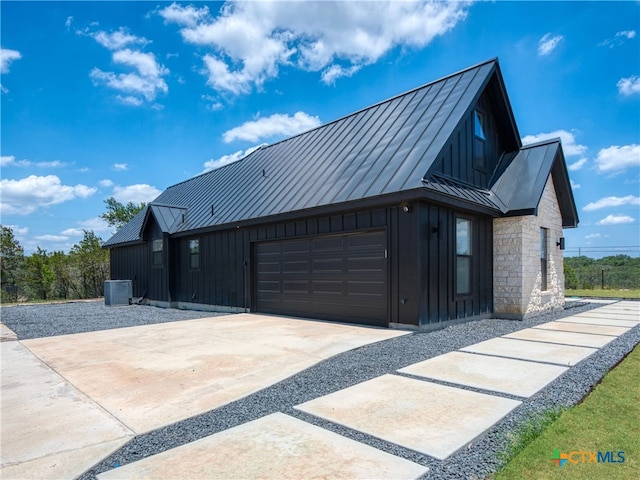 view of side of home with an attached garage, a standing seam roof, and metal roof