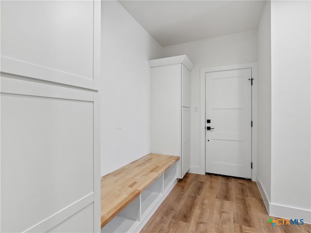 mudroom featuring light wood finished floors and baseboards