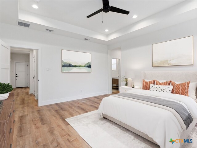 bedroom featuring recessed lighting, baseboards, visible vents, and a raised ceiling