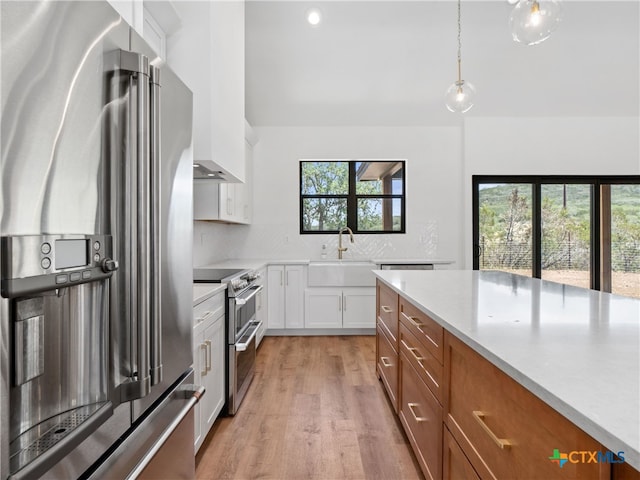 kitchen with high end appliances, light wood-style flooring, and light countertops