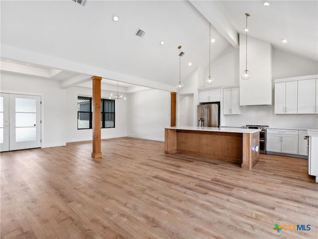 kitchen featuring stainless steel appliances, visible vents, beamed ceiling, a kitchen island, and open floor plan