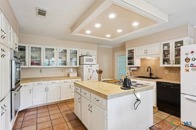 910 Mill Creek Dr, Salado, TX 76571 - kitchen with appliances with stainless steel finishes, light countertops, a kitchen island, decorative backsplash, and light tile patterned floors