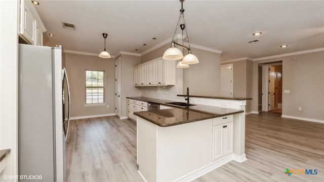 1974 Canyon Bnd, Canyon Lake, TX 78133 - kitchen with freestanding refrigerator, a sink, light wood finished floors, a peninsula, and crown molding