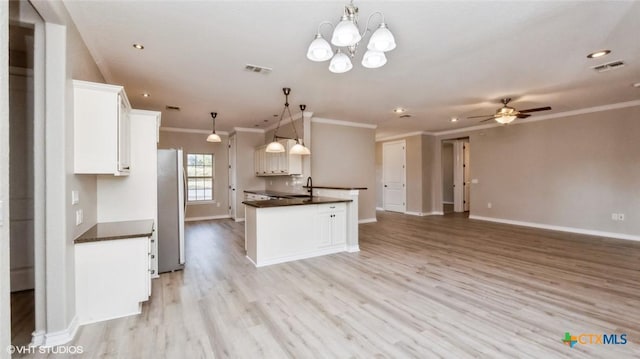 1974 Canyon Bnd, Canyon Lake, TX 78133 - kitchen with freestanding refrigerator, dark countertops, crown molding, white cabinetry, and open floor plan