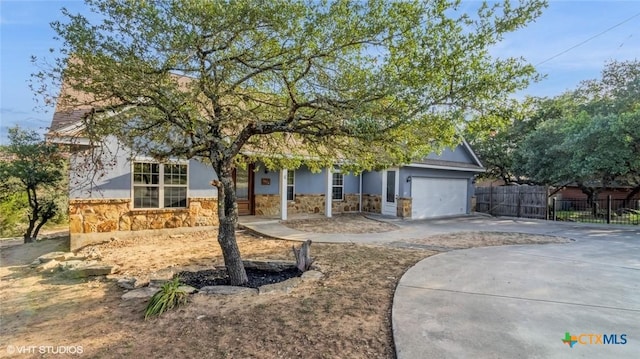1974 Canyon Bnd, Canyon Lake, TX 78133 - view of property hidden behind natural elements with stone siding, driveway, a garage, stucco siding, and covered porch