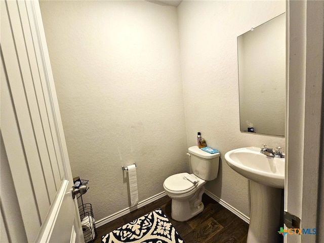 bathroom featuring toilet and wood-type flooring