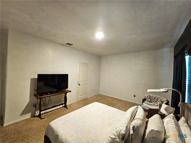 carpeted bedroom featuring a textured ceiling