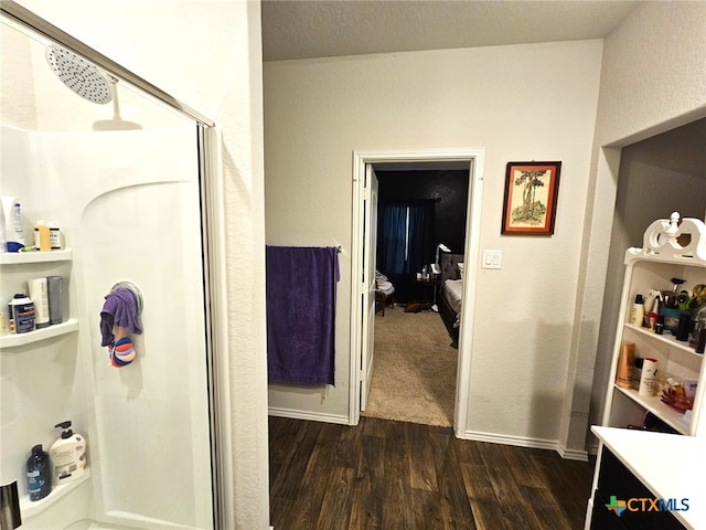 bathroom with hardwood / wood-style floors, vanity, and a shower with door