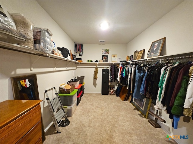 walk in closet featuring light carpet