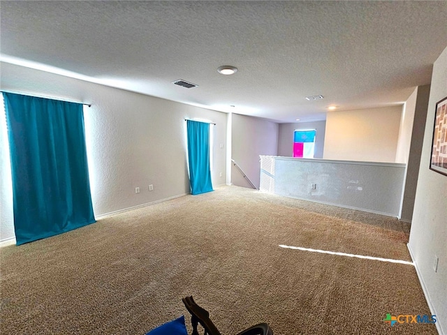 spare room with carpet floors and a textured ceiling