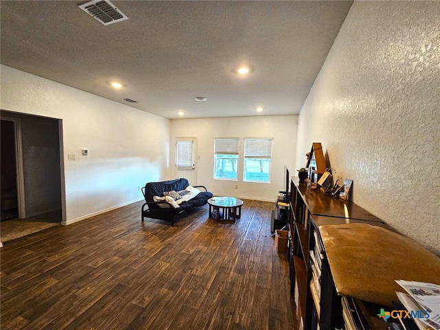 living area featuring a textured ceiling and dark wood-type flooring