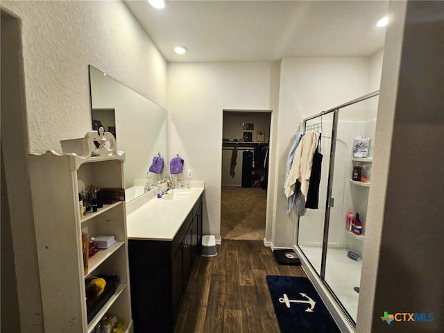 bathroom with hardwood / wood-style flooring, vanity, and an enclosed shower