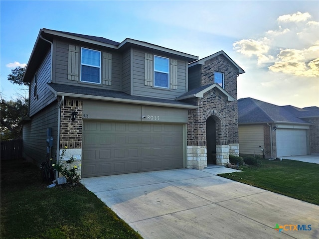 traditional-style home featuring driveway, stone siding, an attached garage, a front lawn, and brick siding