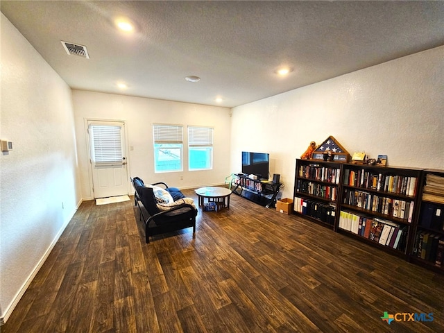 living area featuring dark hardwood / wood-style flooring and a textured ceiling