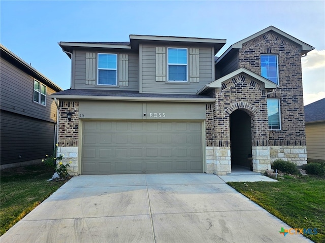 traditional-style home with concrete driveway, stone siding, an attached garage, and brick siding