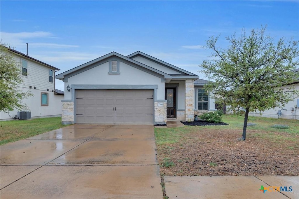 5766 Porano Cir, Round Rock, TX 78665 - view of front facade with stone siding, driveway, an attached garage, and stucco siding