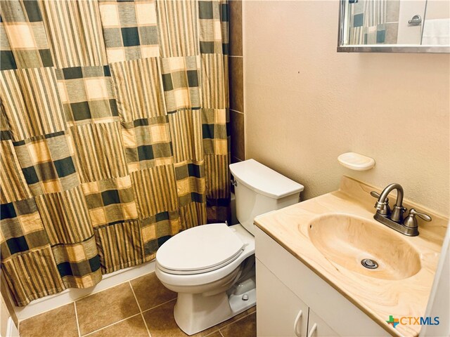 bathroom featuring toilet, walk in shower, vanity, and tile patterned floors