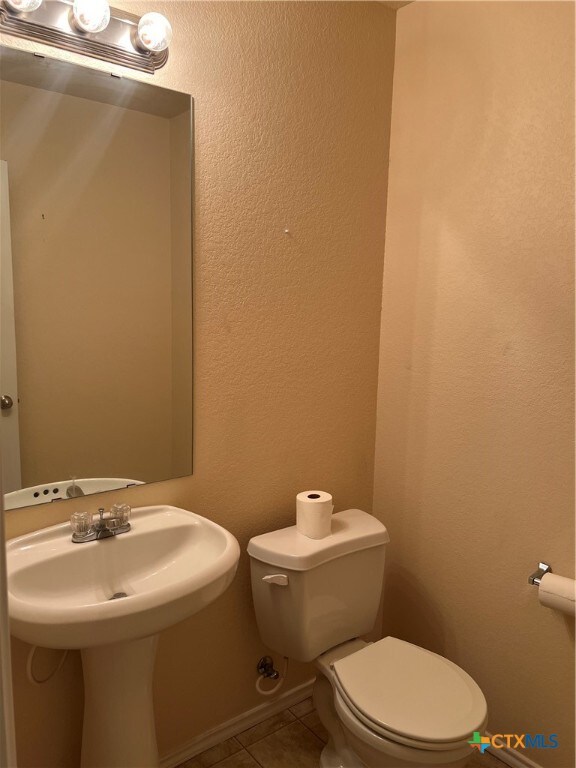 bathroom with toilet and tile patterned floors