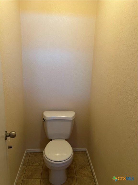 bathroom with tile patterned flooring and toilet