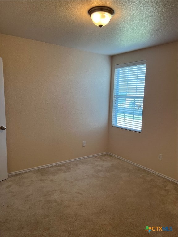 carpeted empty room with a textured ceiling