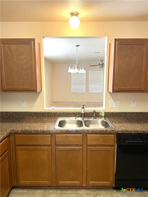 kitchen with sink, ceiling fan, light tile patterned floors, hanging light fixtures, and dishwasher