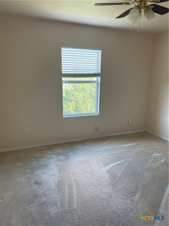 carpeted empty room featuring ceiling fan