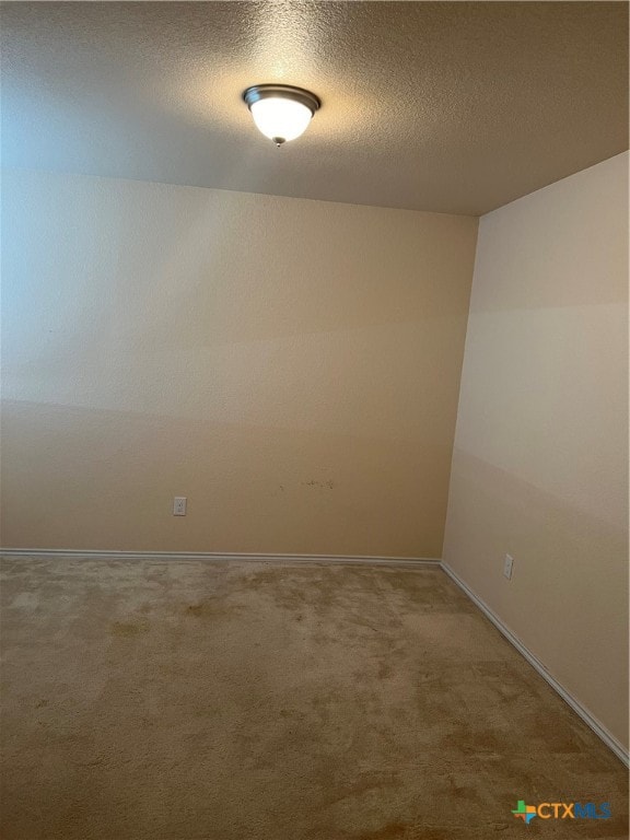 empty room featuring carpet and a textured ceiling