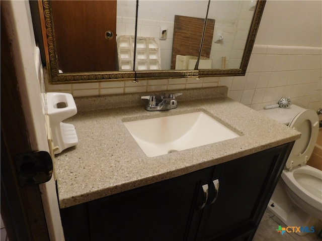 bathroom with tile walls, decorative backsplash, vanity, and toilet