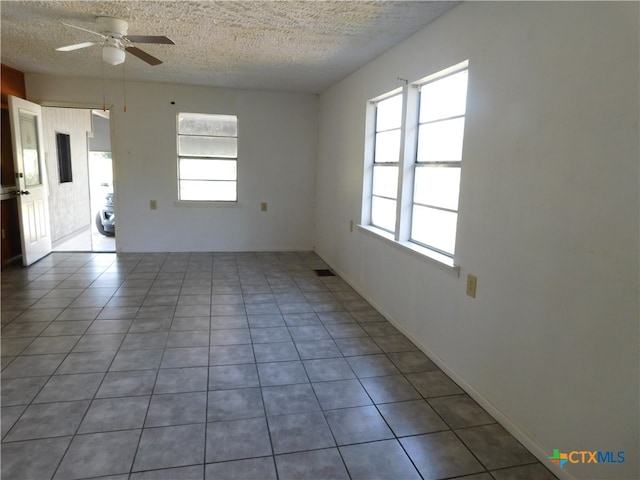 tiled spare room with ceiling fan and a textured ceiling