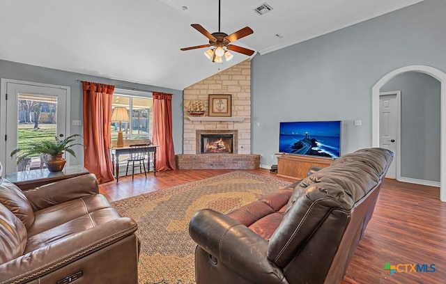 living room with ceiling fan, lofted ceiling, wood-type flooring, and a fireplace