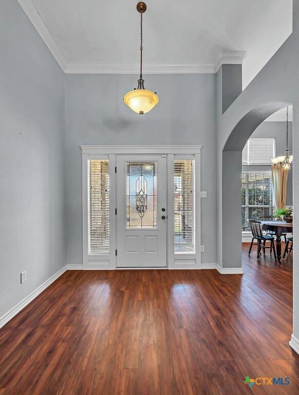 foyer entrance featuring crown molding, dark hardwood / wood-style flooring, and a chandelier