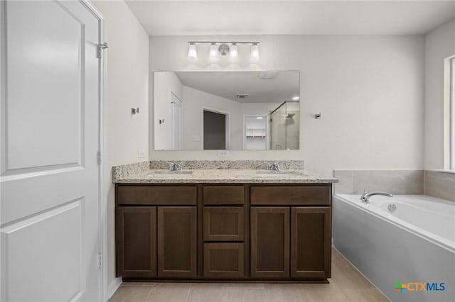 1821 Holleman Dr, Temple, TX 76502 - bathroom with double vanity, a bath, a shower stall, and tile patterned floors