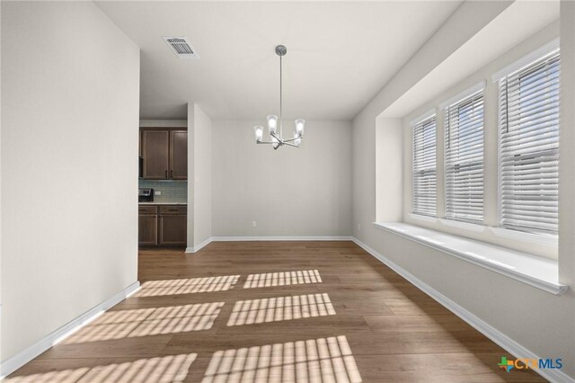 1821 Holleman Dr, Temple, TX 76502 - unfurnished dining area with a chandelier and light wood-style floors