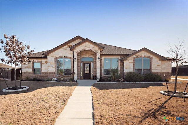 french country home with brick siding and stone siding