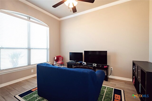 home office with baseboards, ornamental molding, a ceiling fan, and light wood finished floors