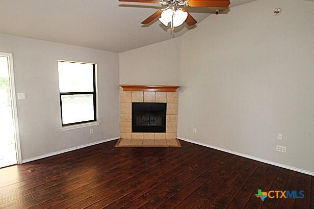 1213 Marlee Cir, Copperas Cove, TX 76522 - unfurnished living room with hardwood / wood-style floors, vaulted ceiling, ceiling fan, a tile fireplace, and baseboards