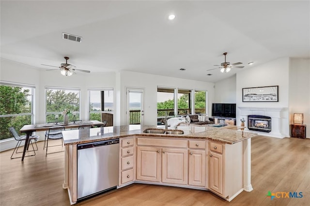 kitchen featuring stainless steel dishwasher, ceiling fan, a sink, open floor plan, and vaulted ceiling