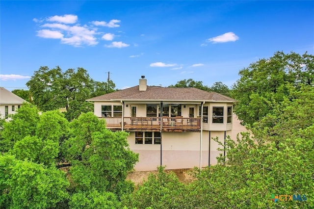 back of property featuring a chimney and stucco siding