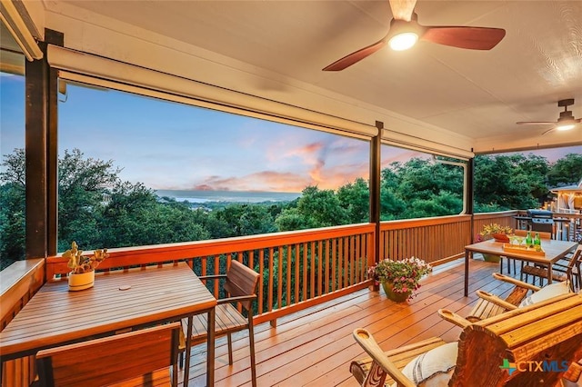 wooden deck with outdoor dining space and ceiling fan