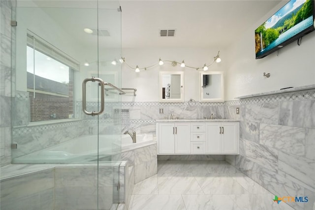 bathroom featuring vanity, shower with separate bathtub, and tile walls