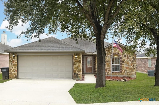 view of front of property with a garage, central AC, and a front lawn