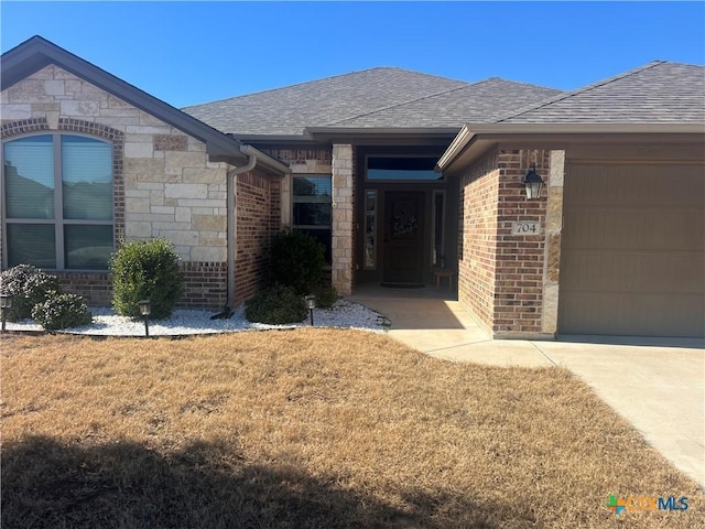 property entrance with a garage and a lawn