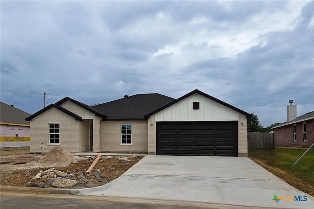 1421 Fossil Trl, Belton, TX 76513 - view of front of home with a garage, board and batten siding, driveway, and brick siding