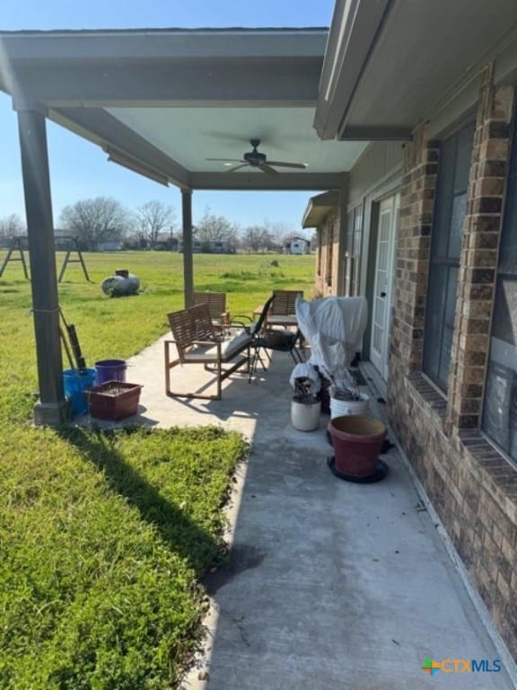 view of patio with ceiling fan and an outdoor fire pit