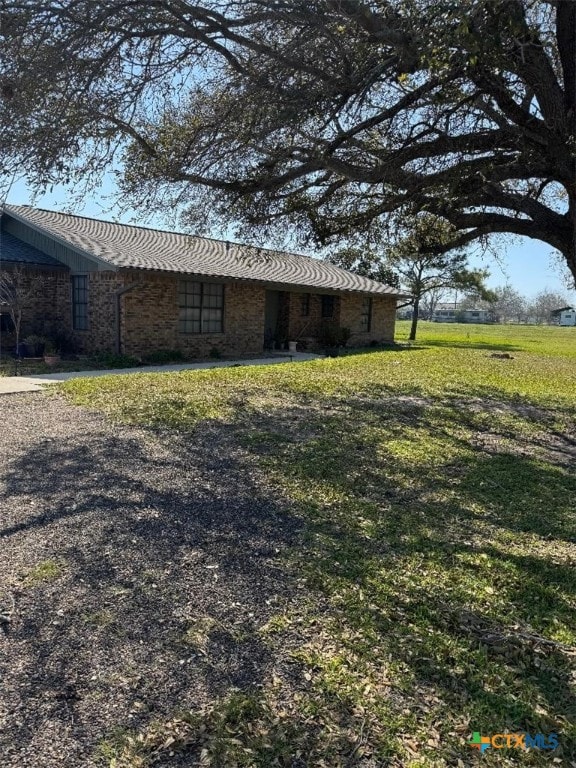 view of property exterior featuring a yard and brick siding