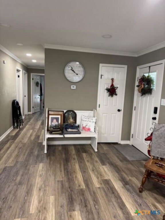 foyer featuring dark wood-style floors, baseboards, and ornamental molding