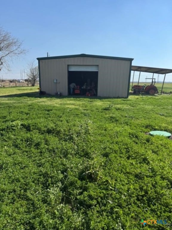 view of pole building with a carport and a lawn